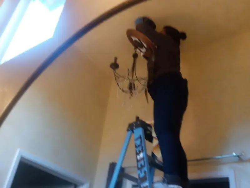 Electrician installing a chandelier in a Elizabeth residence